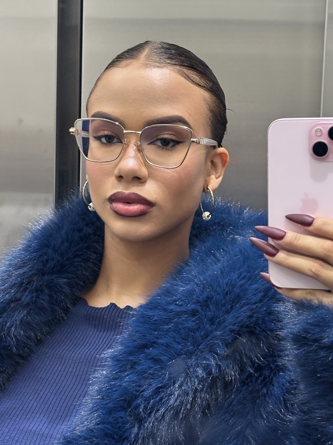 Andrea Mena con gafas y abrigo azul